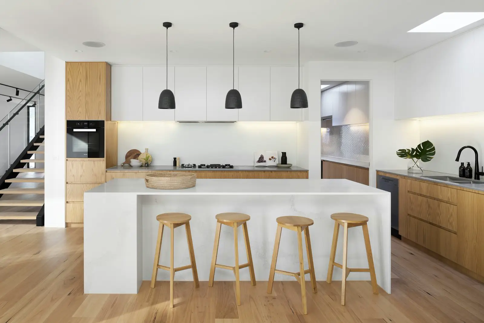 A white kitchen island with wood cabinets and stools. Shown on the homepage for San Jose, CA.