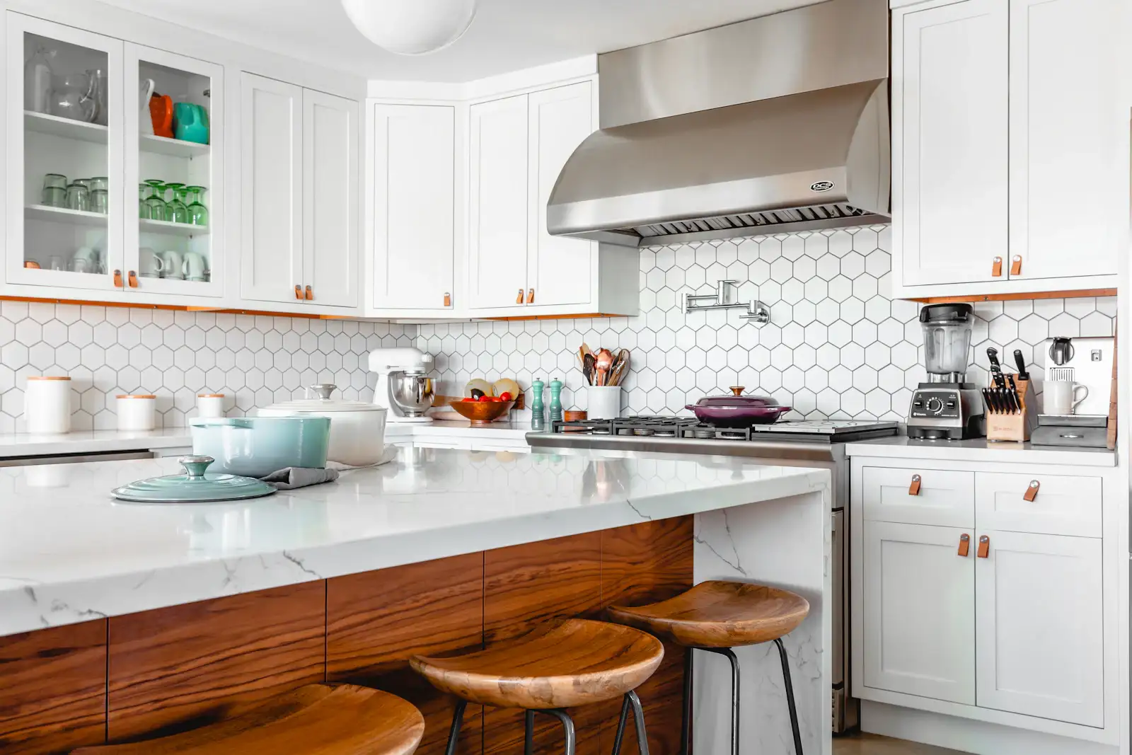 A white kitchen with a marble island and a range hood. Shown on the Counter plan page for San Jose, CA.